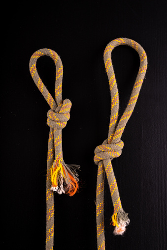 Two loops made of thick rope. Loop-shaped knot. Dark background.