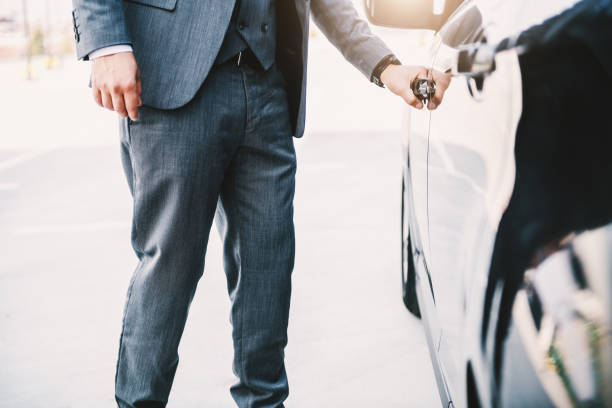 istock Sophisticated rich businessman opening his car. 1201026541