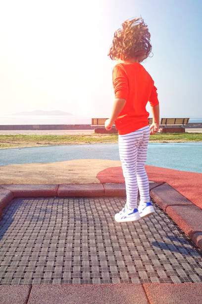 Candid portrait of cute little girl with long blonde wet hair leaning towards the camera