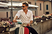 Handsome man sitting on old classic scooter