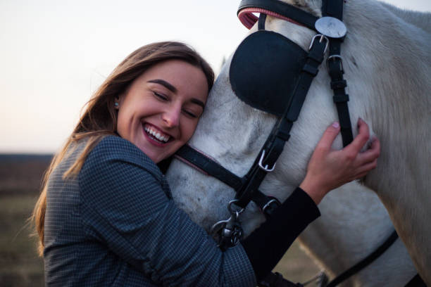 乗馬学校で彼女の白い馬のリピッツァンを抱きしめる美しい若い女の子 - vet veterinary medicine young women female ストックフォト��と画像
