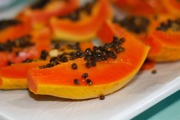 istock fresh sliced papaya with seeds on tray. 1201029774