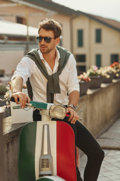 istock Handsome man sitting on old classic scooter 1201030841