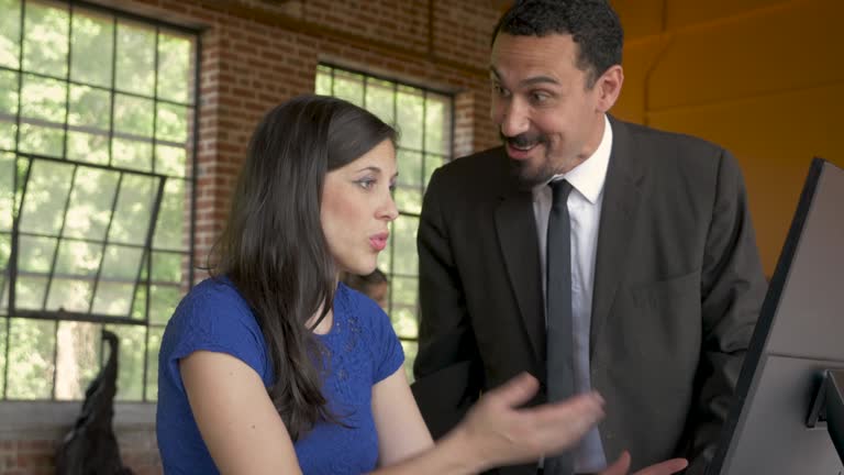 Young woman employee trying to explain herself to her angry boss