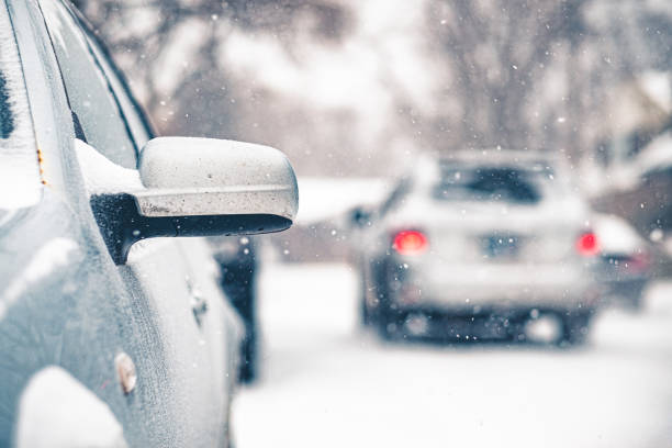 A sleek and stylish black car is partially buried in fresh, soft snow, perfectly showcasing a serene winter scene