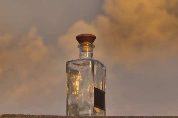 istock low view of a clear glass bottle, reflecting the evening sky. 1201032603