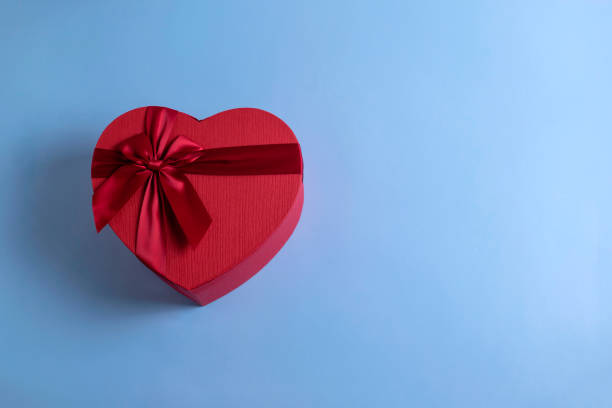 istock Red heart shaped gift box with a ribbon on blue pastel background with copy space for your text. 1201036241