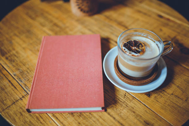 istock Book and a cup of latte on wooden table 1201039673