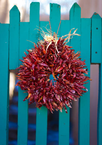santa fe stil: rote ristra kranz auf türkis/grünes tor - wreath chili pepper pepper ristra stock-fotos und bilder
