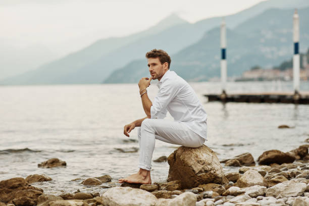 istock Handsome man in casual clothing relaxing on the beach 1201043173