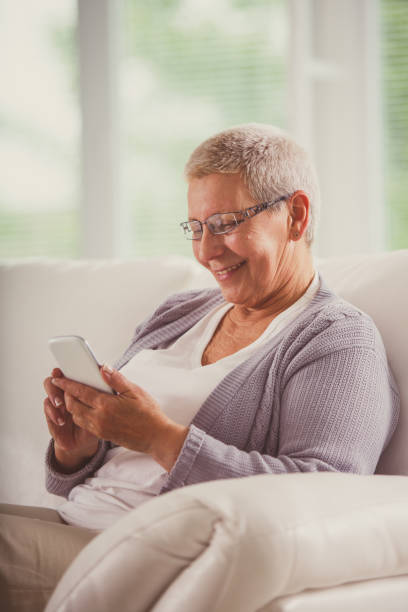 istock Senior woman dialing a number on her smart phone 1201050025