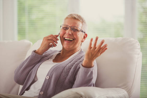 istock Senior woman having a laugh while talking over phone 1201050038
