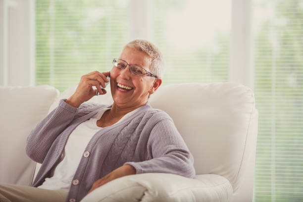 istock Cheerful senior woman laughing while talking over her mobile phone 1201050040