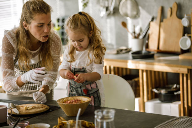 istock Little girl adding bananas as a decoration on a dessert 1201050205
