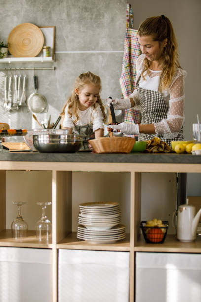 istock Mother and daughter bonding while preparing a banana snack 1201050213