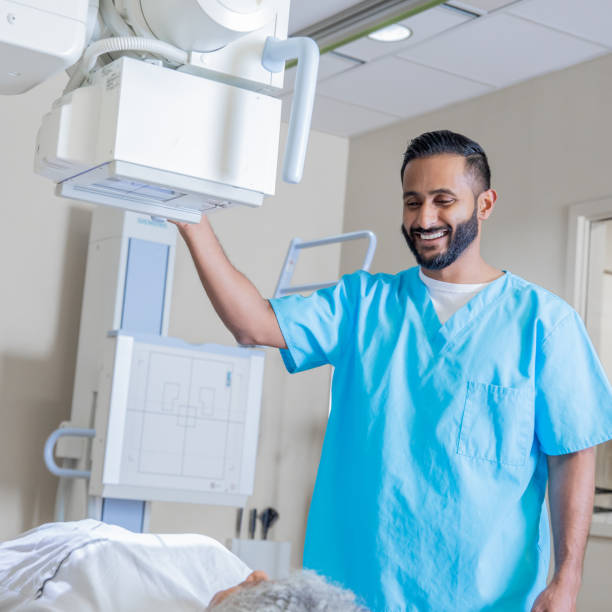 istock Male technician taking X-rays of female patient 1201050311