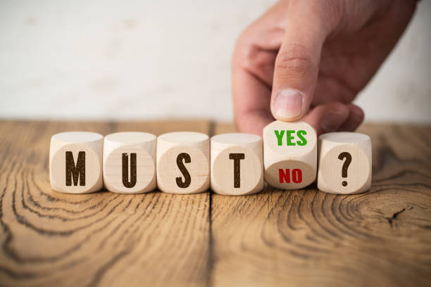 istock hand is turning wooden cube with yes an no answer to the question 