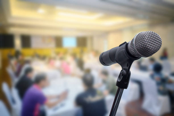 istock Microphone over the blurred business forum Meeting or Conference Room Concept, Blurred background. 1201053144