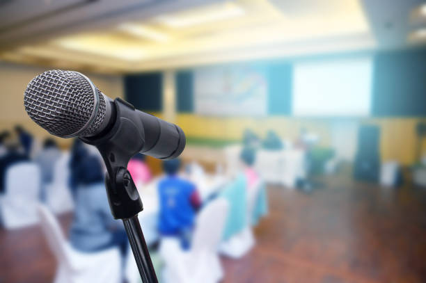 istock Microphone over the blurred business forum Meeting or Conference Room Concept, Blurred background. 1201053172
