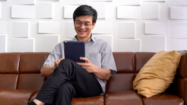 istock Asian old man video call on a digital tablet at home 1201065171