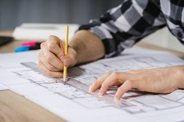 istock Young adult architect businessman working in modern studio with blueprints 1201072518