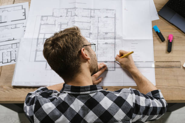 istock Young adult project manager and architect working in professional bureau with blueprints 1201072544