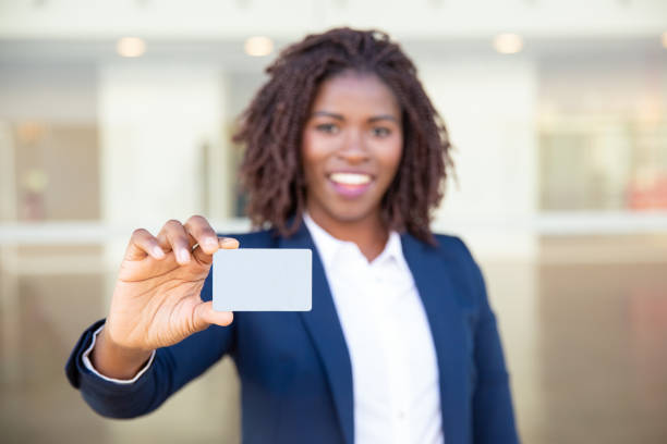 alegre empresaria sosteniendo tarjeta en blanco - smiling business card horizontal women fotografías e imágenes de stock