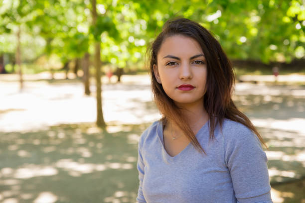 istock Beautiful young woman standing and looking at camera 1201108651