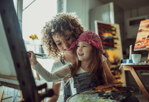 istock Mother and daughter painting together 1201109331