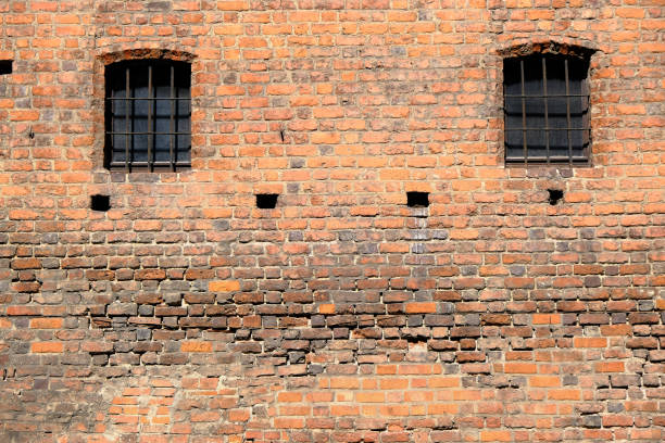 istock Two windows of red bricks old vintage prison wall. Abstract architectural loft background for design. 1201110459