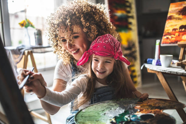 istock Mother and daughter painting together 1201110663
