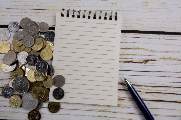 istock Pen,notebook,coins and coffee. General concept of business. Copy space 1201110738