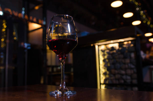 istock Glass of red wine on backlighted background 1201111335