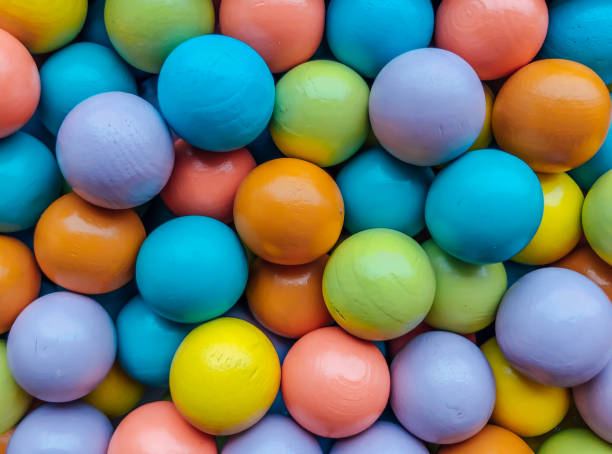 istock Bright multi-colored background from small wooden colored balls from the developmental toys. 1201112875
