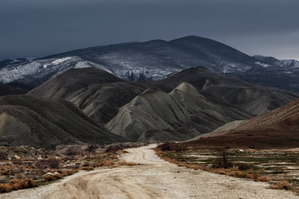 Photo of Dirt road to the mountains at stormy weather