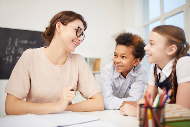 istock Young teacher with children in the classroom 1201115825