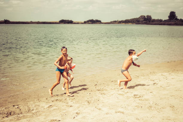 istock Happy boys having fun on the beach in summer day. 1201118011