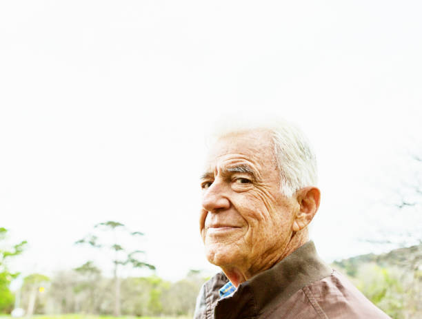 istock Senior man outdoors turns to camera, smiling impishly 1201118127