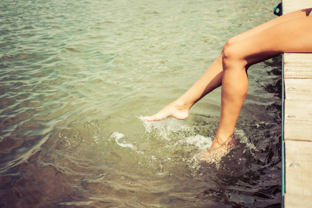 istock Unrecognizable woman splashing water while relaxing on a pier. 1201118162