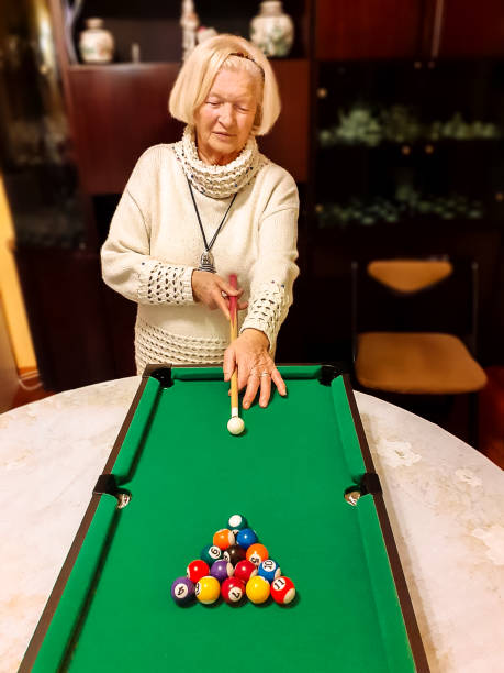 istock Senior woman playing billiard pool 1201125652