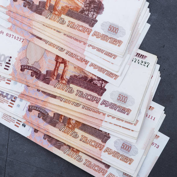 istock Big stack of Russian money banknotes of five thousand rubles lying on a grey cement background. 1201131403