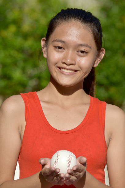 istock Diverse Female Baseball Player Smiling With Baseball 1201131939