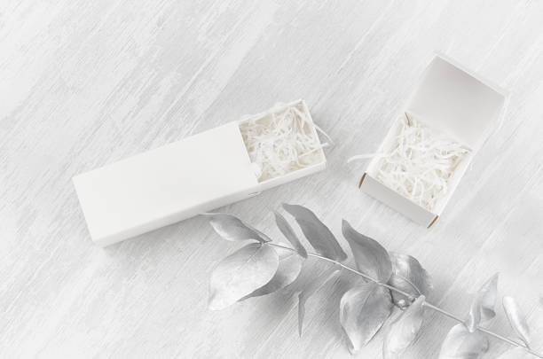 Soft light white blank open two gift boxes - square, rectangle filler mock up on wood board silver branch top view for design, branding identity, advertising.