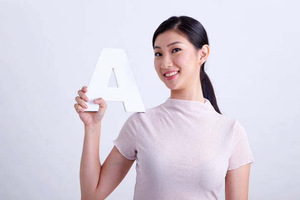 istock chinese woman holding alphabet a 1201141755