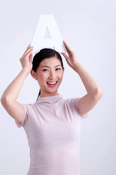 istock chinese woman holding alphabet a 1201141813