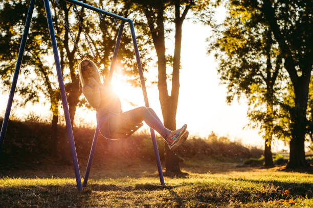 istock Woman on a swing in a park 1201143336