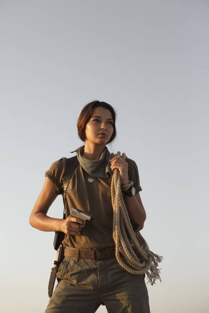 mulher em pé com uma arma ao ar livre no deserto - gun women handgun armed forces - fotografias e filmes do acervo