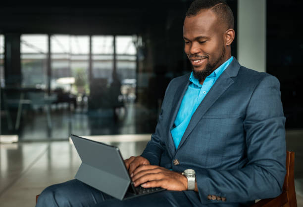 istock Corporate executive Black African businessman typing on a digital tablet computer with attached keyboard 1201144130