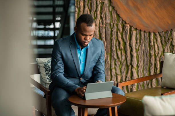 istock Corporate executive Black African businessman typing on a digital tablet computer with attached keyboard 1201144153
