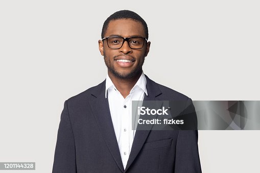 istock Smiling black man in suit posing on studio background 1201144328